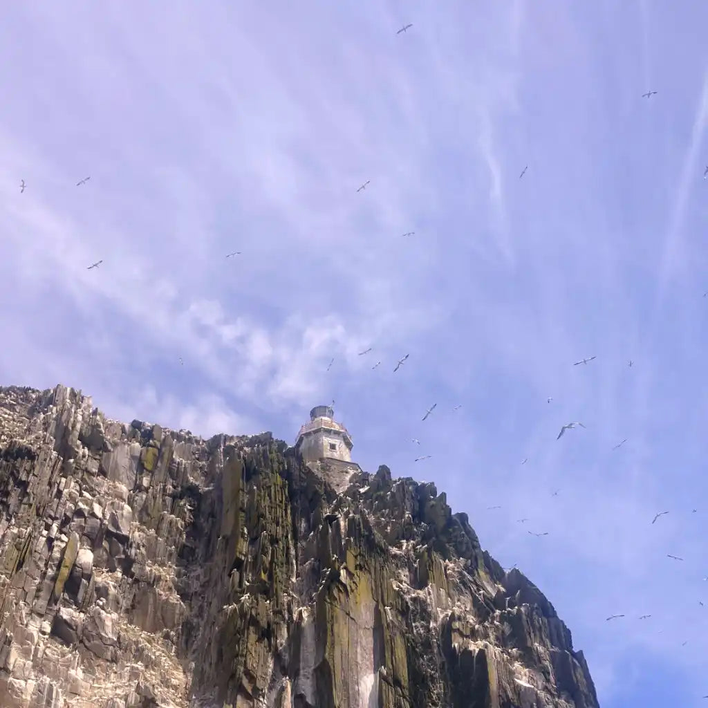 Bull Rock lighthouse seen from the sea on top of the rock