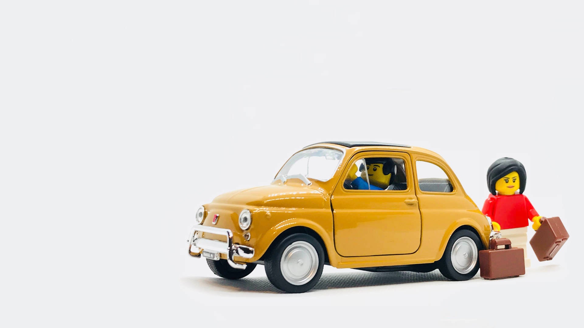 Fiat 500 toy car with 2 lego holiday figurines.
